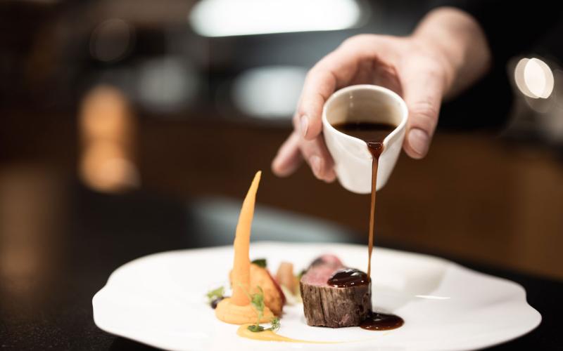 Detailansicht eines Desserts, das gerade noch verziert wird im Naturhotel Outside