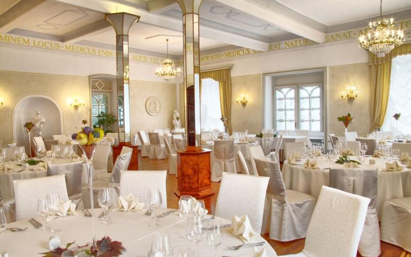 Restaurant mit hellen Stühlen und festlich gedeckten Tischen im Hotel Zdravilisce Lasko