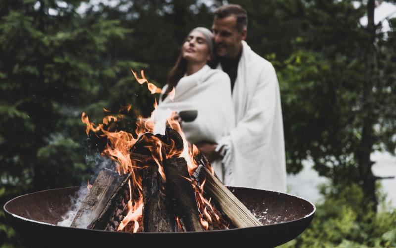 Seehotel Jägerwirt ****s Paar im Bademantel bei einer Feuerschale im Seehotel Jägerwirt