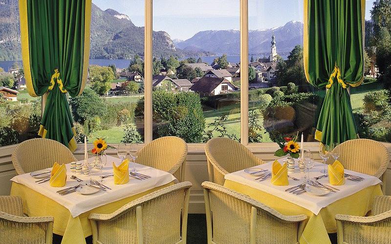 Blick auf einen gedeckten Tisch mit Aussicht auf den Wolfgangsee vom Hotel Hollweger Wintergarten aus