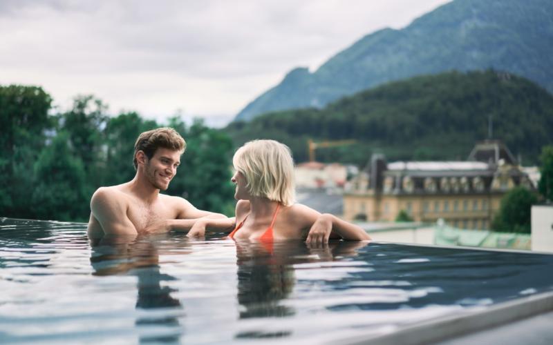 Ein Paar im Aussenpool mit Blick in den Ort im EurothermenResort Bad Ischl Hotel Royal