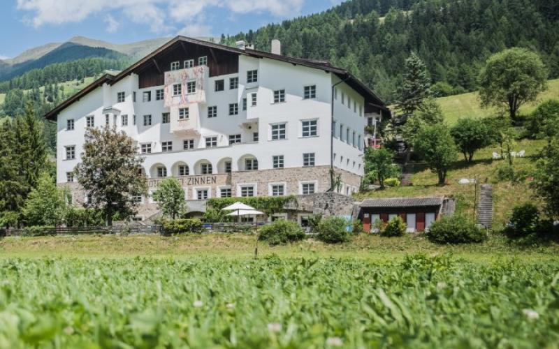 Frontalansicht des Hotels Drei Zinnen und der umliegenden Landschaft