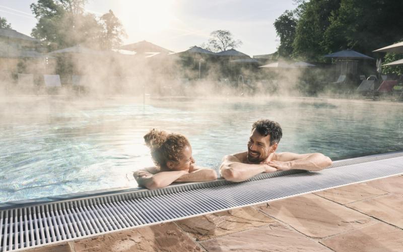 Ein Paar genießt den Aussenpool im EurothermenResort Bad Hall Hotel Miraverde
