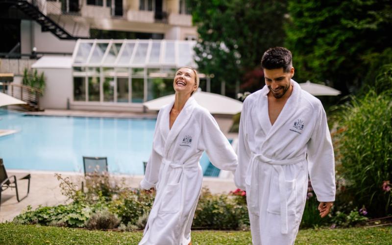 Ein Paar im Bademantel im Garten des Hotels Warmbaderhof
