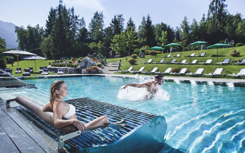 Gäste beim Aussenpool mit Ruheliegen und großen Liegewiesen im Hotel Klosterbräu und Spa