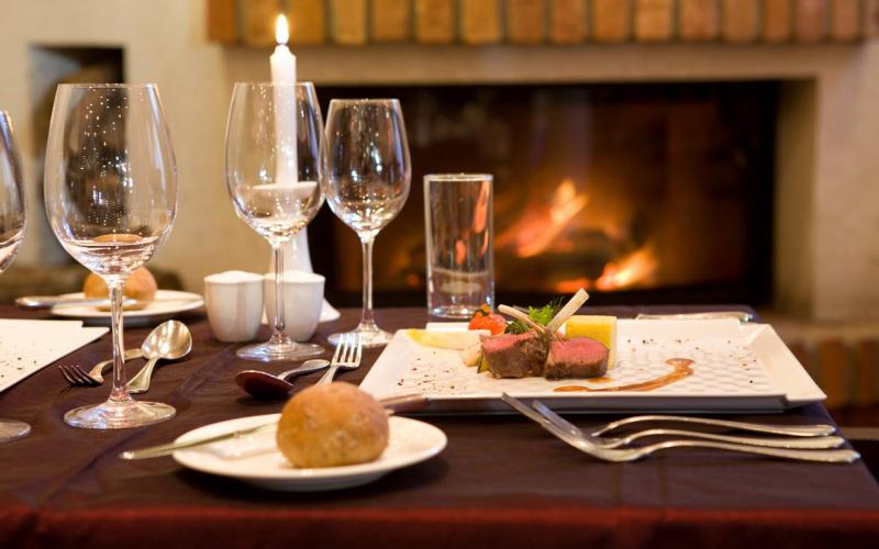 Ein schön gedeckter Tisch neben dem Kamin in der Lotus Therme Hotel und Spa