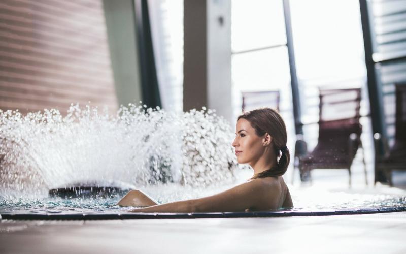 Eine Dame im Pool mit Springbrunnen imn der Terme Vivat