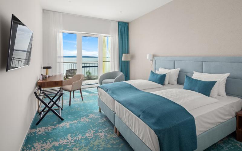 Doppelzimmer mit türkisem Dekor und Blick auf den Plattensee im Hotel Sirius