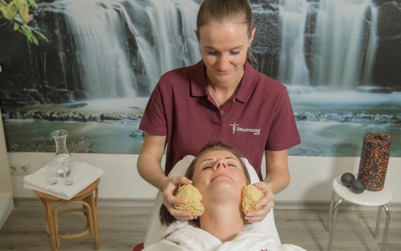 Eine Dame genießt eine Behandlung durch eine Therapeutin im Hotel Palace