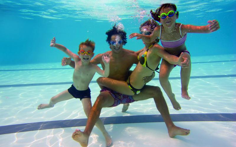 Eine Familie unter Wasser im Pool des H2O Hotel-Therme-Resorts
