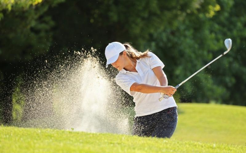Eine Frau beim Golfspielen in der Nähe des Hotels Der Lärchenhof