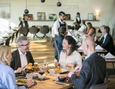 Gäste genießen das Abendessen mit schön gedeckten Tischen im ARCOTEL Nike Linz