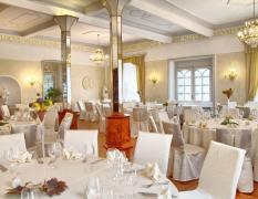 Restaurant mit hellen Stühlen und festlich gedeckten Tischen im Hotel Zdravilisce Lasko