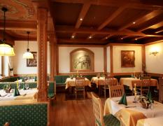 Landhotel Strasserwirt Blick in den Speisesaal im Landhausstil mit gedeckten Tischen im Landhotel Strasserwirt