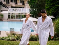Ein Paar im Bademantel im Garten des Hotels Warmbaderhof