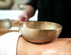 Ein Gast bei einer Klangschalenbehandlung im Wellnessbereich des Impuls Hotels Tirol