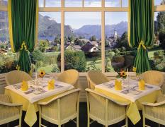 Blick auf einen gedeckten Tisch mit Aussicht auf den Wolfgangsee vom Hotel Hollweger Wintergarten aus