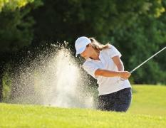 Eine Frau beim Golfspielen in der Nähe des Hotels Der Lärchenhof